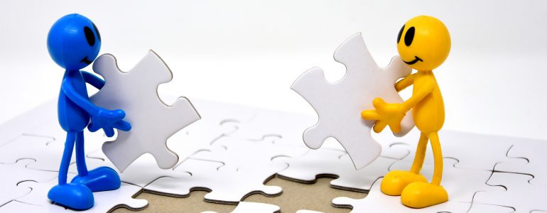 two people putting together puzzle pieces